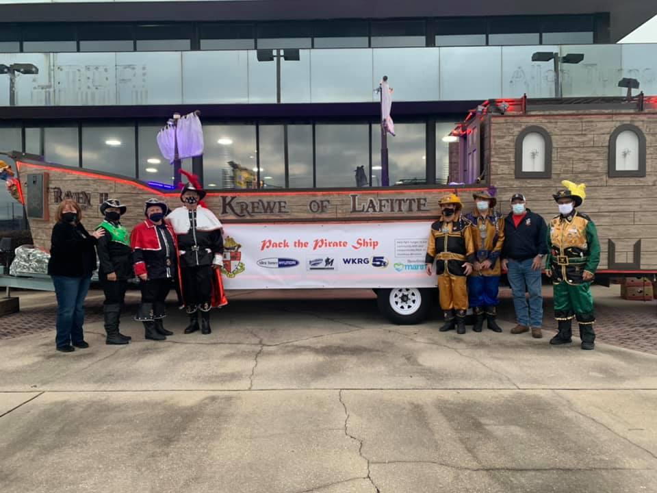 Krewe of Lafitte members stand near one of the ships used for groceries inside the ship for the 2020 Fill the Pirate Ship food drive, which was used to collect donations to the Manna Food Bank. This year's event also collects food and cash donations to feed the hungry in Escambia and Santa Rosa counties.