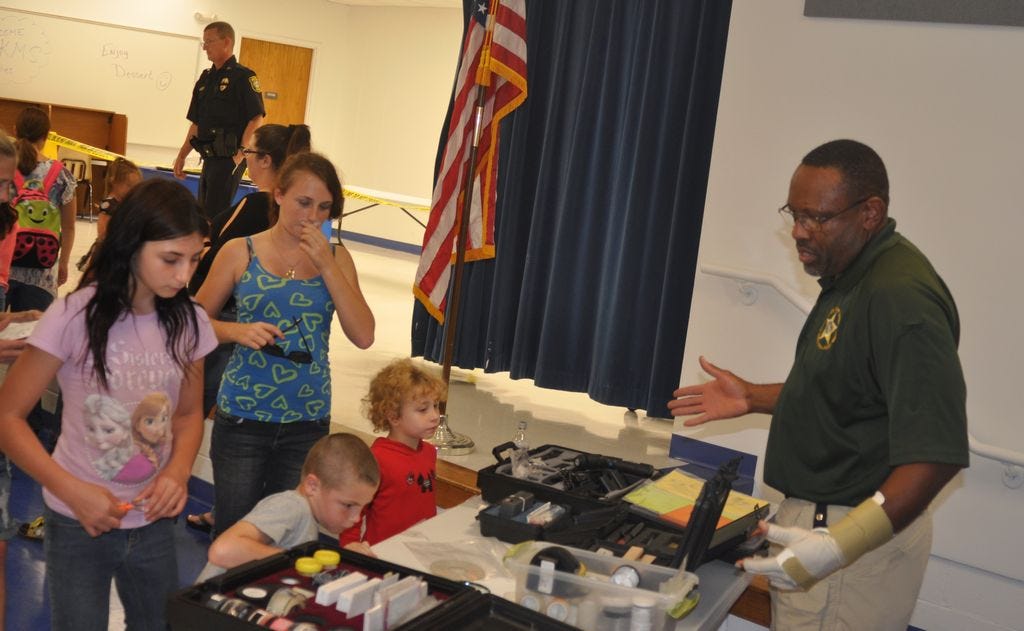 Charlie Peters, right, the Crime Scene Unit Supervisor for the Santa Rosa County Sheriff's Office shows King Middle School students tools his department uses to work an actual crime scene.