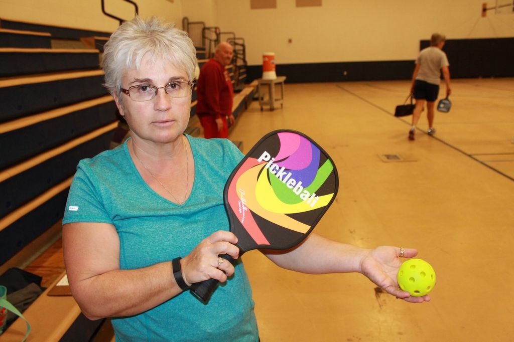 Pickleball incorporates elements of tennis, racquetball, and badminton, Valinda Dudley, pickleball player said. The paddle is short like a racquetball racket but wooden and so has less give. The ball resembles a small Wiffle ball. It doesn’t bounce like a tennis ball and has more curve potential. Keeping up with the score is harder than keeping up with the ball.
