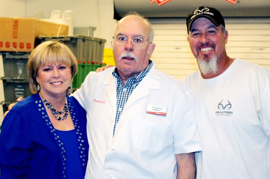 Pharmacist Tom Weekley, center, received a surprise Monday as his coworkers and family honored his 40th year serving Santa Rosa County residents.