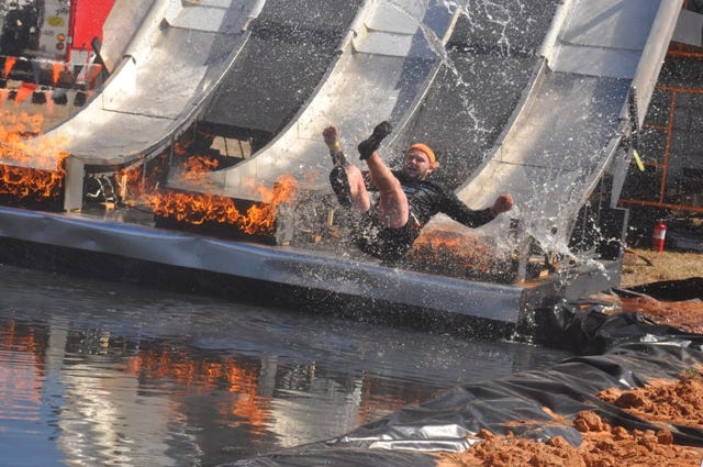 Either before or after participating in the ‘Tough Mudder’ obstacle course, participants could get a thrill with the ‘Fire in your Hole’ obstacle located in the Mudder Village. Participants would climb onto the tower, slide down a steep water slide while passing through flames into a pool.
