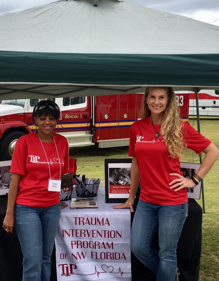 Deanna Smith, executive director, and Linda Hunter, crisis team manager, of Trauma Intervention Programs, Inc. of Northwest Florida, educate the community on their program at a booth during a local event. [Special to the Press Gazette]