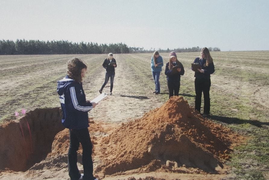 Local high school students examine four pits during the County Land Judging Contest. [Special to the Press Gazette]
