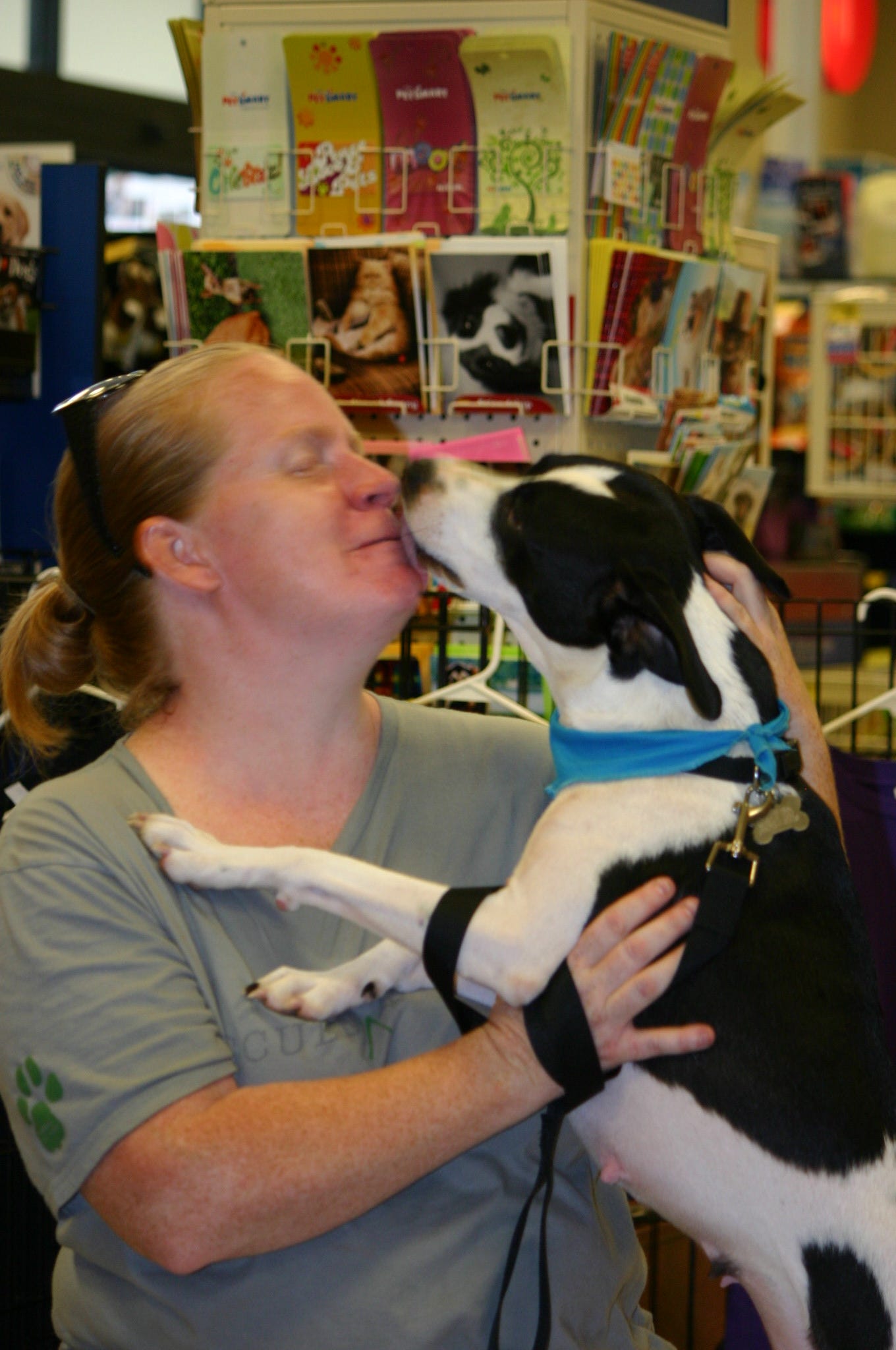 Bessie Moo, one of the many dogs that could be adopted this past Saturday, August 9th at PetSmart in Pace shows his appreciation for SouthBark Volunteer Jenny Bilbery.