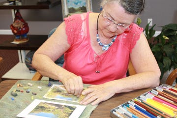 Sandi Lang, pastel in hand, examines her work. Thursday, she took part in the pastel class at the Dragonfly Gallery along with Rodie Zolecki, Jan Shelby, Jan Rich, and Eleanor Williams under the tutelage of Elaine Woodward.