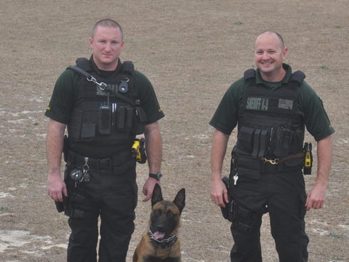 K-9 deputies Jeff Perkins, left, and Doug Burgett stand next to Â‘RogueÂ’ one of the newest members of the Santa Rosa County SheriffÂ’s Office. Both Perkins and Burgett are two of the latest additions to the force, which now consists of six deputy and K-9 partners. BurgettÂ’s K-9 Â‘ZurkiÂ’ was unable to be pictured due to a slight illness.