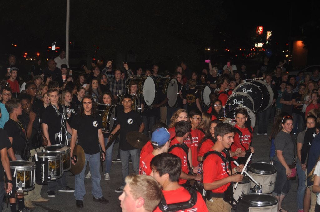 Members of the Milton (in black t-shirts) and Pace (in red t-shirts) high schools perform in a drumline competition during Tuesday night's 'Bring the Heat' event at the Whataburger restaurant in Pace. PHS won $1500 worth of donation prizes during a jalapeno eating contest and bringing the most fans to the fundraising event.